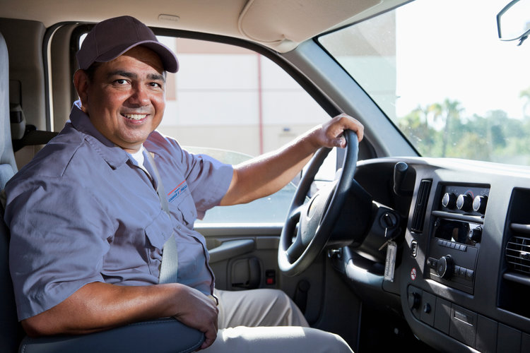 One of Our Courier driver behind the wheel smiling