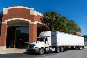 Semi-truck parked in front of KanjiTrans Services corporate building